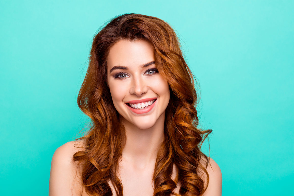Close up portrait of lovely, cute, sweet, gorgeous, nice, stunning, adorable, good-looking woman with big toothy smile, curly ginger hairstyle look in camera isolated on bright teal background