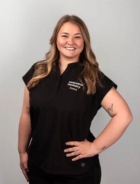 Distinctive Dentistry team member Emma in branded black scrubs