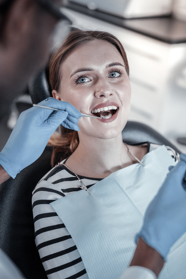 It is ok. Pleased blonde girl keeping smile on her face while looking at her doctor